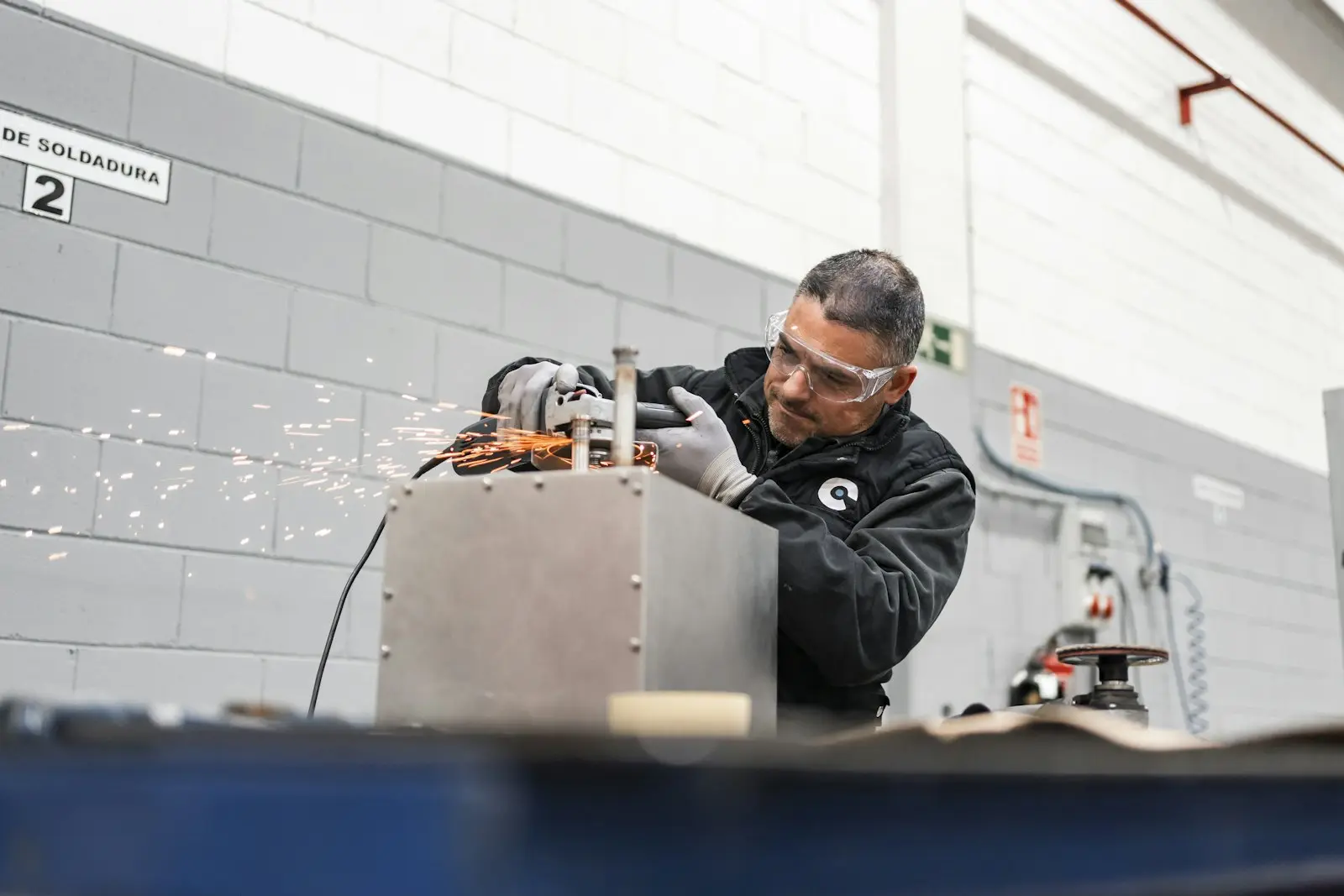 Arbeiter schleift Metall, Funken fliegen