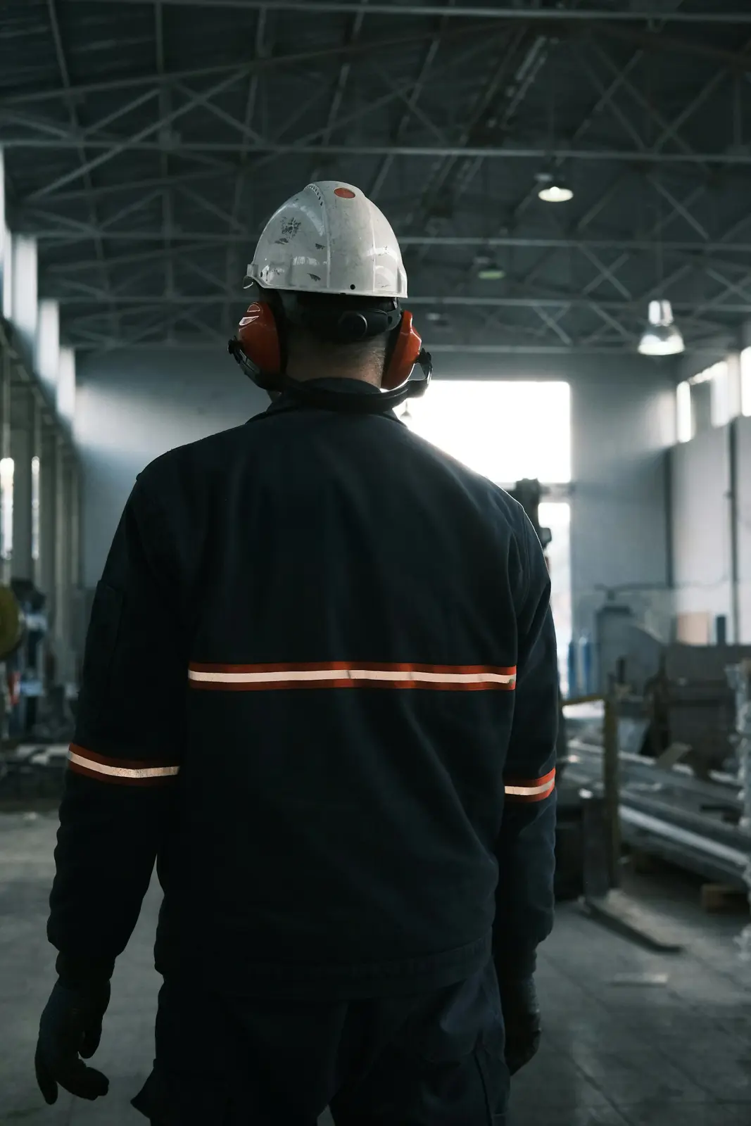 Techniker mit Helm geht durch eine Halle